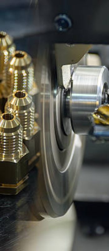 Abstract scene the multi tasking CNC lathe machine and the group of brass male fitting connector parts. The metalworking process by turning machine.